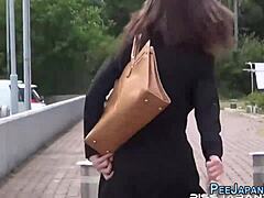 Az ázsiai nő a szeretője előtt pisil az utcán