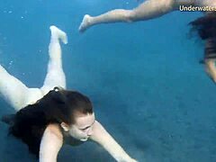 En rödhårig tjej och en blond tonåring utforskar varandras kroppar i poolen