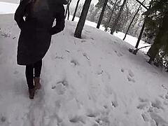 Красива руса жена се наслаждава на снега с партньора си