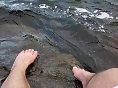 Mikas große und haarige Füße genießen barfußes Spiel im Wasser