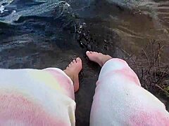 Mika's grote en harige voeten genieten van blote voeten spelen in het water